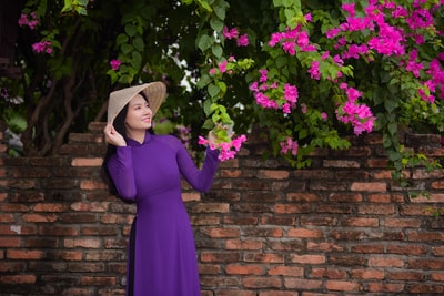 女人紫色长袖礼服站在紫色的花
